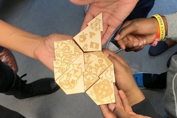 Hands holding small pieces of wood with images etched into them